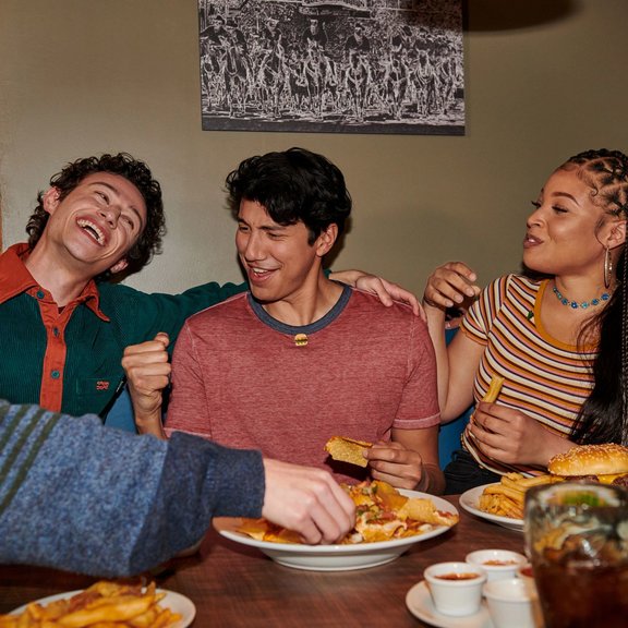 Group of young adults eating at a table.
